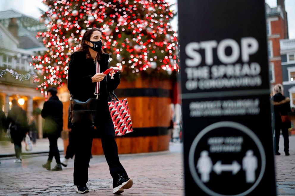 PHOTO: A woman wearing a face mask to combat the spread of the novel coronavirus walks past the Christmas tree in Covent Garden in central London on Nov. 27, 2020, as life under a second nationwide lockdown continues in England.