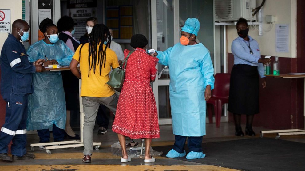 PHOTO: A health worker checks the temperature of an elderly patient at the emergency entrance of the Steve Biko Academic Hospital in Pretoria, South Africa, Jan. 11, 2021, which is battling an ever-increasing number of COVID-19 patients.