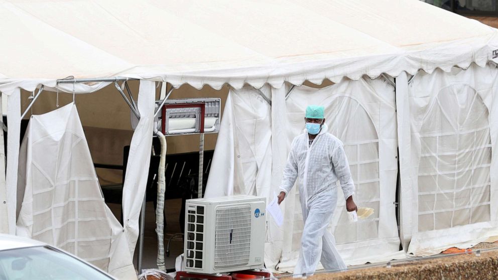PHOTO: A health worker walks past tents erected at the parking lot of the Steve Biko Academic Hospital, amid a nationwide COVID-19 lockdown, in Pretoria, South Africa, Jan. 11, 2021.