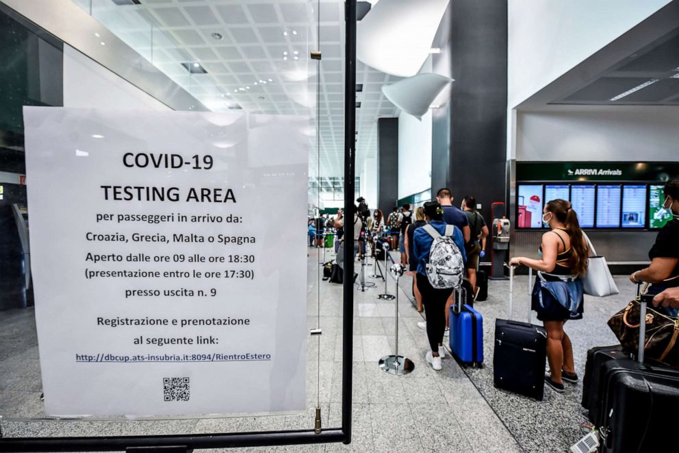 PHOTO: Passengers arriving from four Mediterranean countries at Italy's Milan Malpensa Airport wait in a line to be tested for COVID-19 on Aug. 20, 2020.