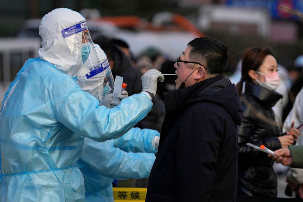 PHOTO: A man gets a throat swab for a COVID-19 test at a mobile testing facility outside commercial office buildings in Beijing, China, on Jan. 17, 2022.