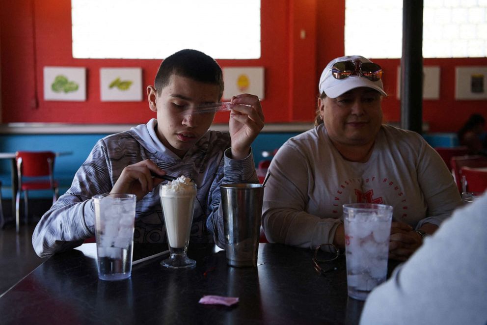 PHOTO: Julius Garza, 14, accompanied by his mother, Margaret Garza drinks a milkshake at Cheesy Jane's in San Antonio, Texas, March 25, 2022.