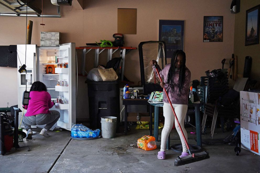 PHOTO: Justise McGowan, 13, helps her mother, Dr. Sandra McGowan-Watts, clean out the garage that her father, who died from the coronavirus disease in May 2020, used as a "man cave" in Matteson, Ill., March 15, 2022.