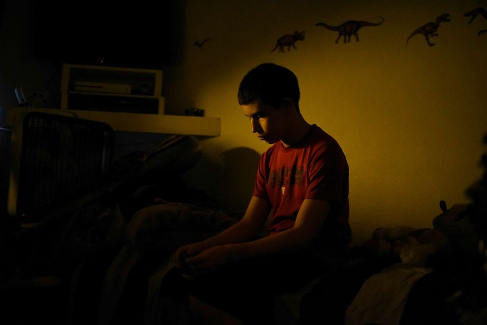 PHOTO: Julius Garza, 14, whose father died from the coronavirus disease in December 2020, sits on his bed at home in Converse, Texas, Feb. 27, 2022.