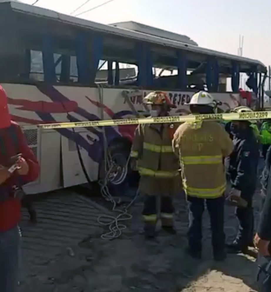 PHOTO: Firefighters stand next to a bus at a crash site in Joquicingo, near Mexico City, Nov. 26, 2021, in this screen grab obtained from a social media video.