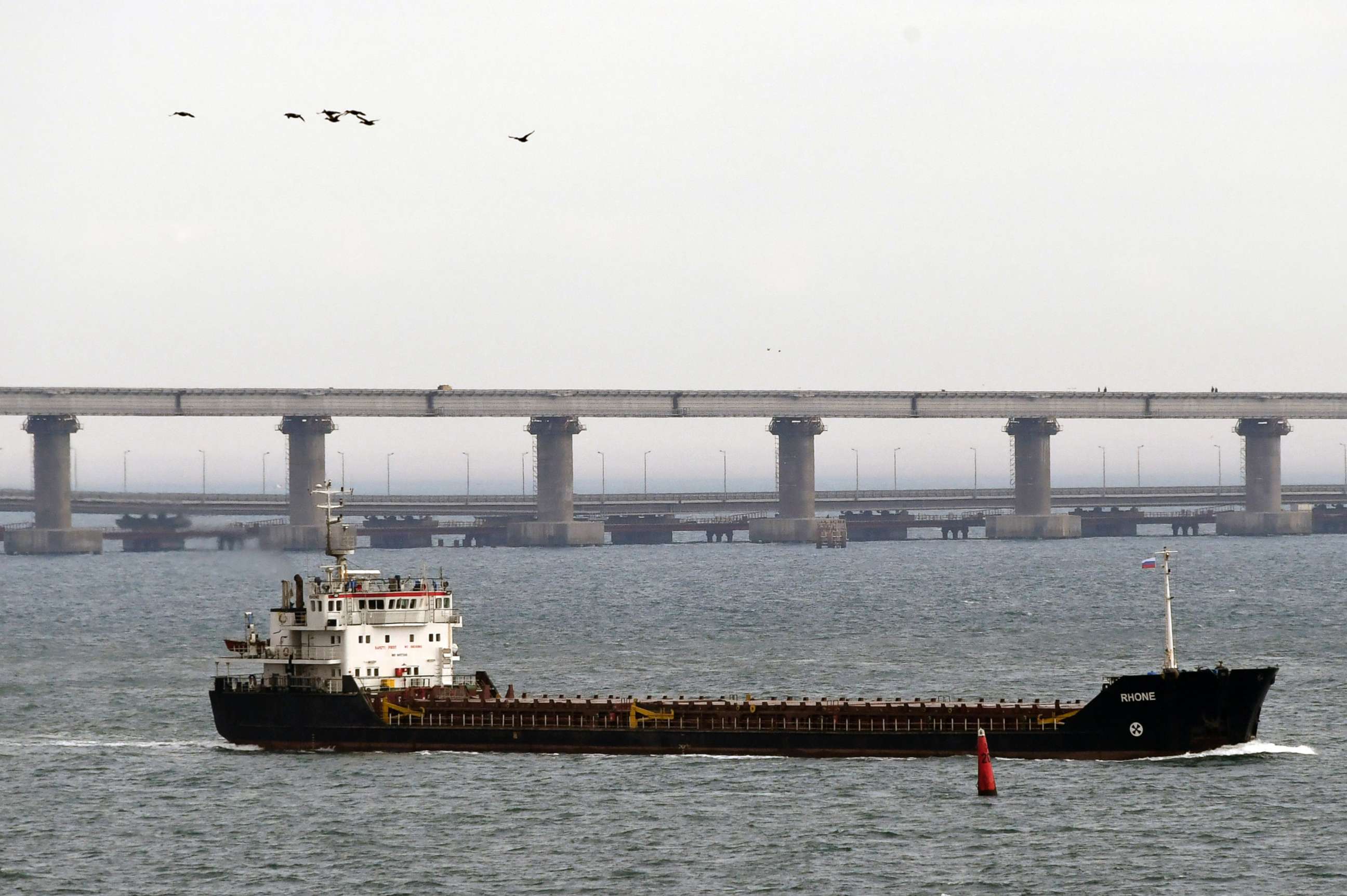PHOTO: A ship makes its way near to the Kerch bridge, in background, near in to Kerch, Crimea, Nov. 26, 2018.