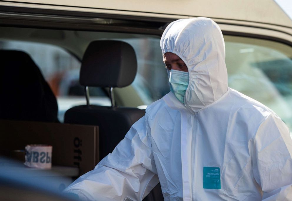 PHOTO: A forensic expert arrives, May 13, 2019, to a cordoned off house in Wittingen, Germany, where two bodies were found during an investigation into the deaths of three people killed by crossbow bolts. 