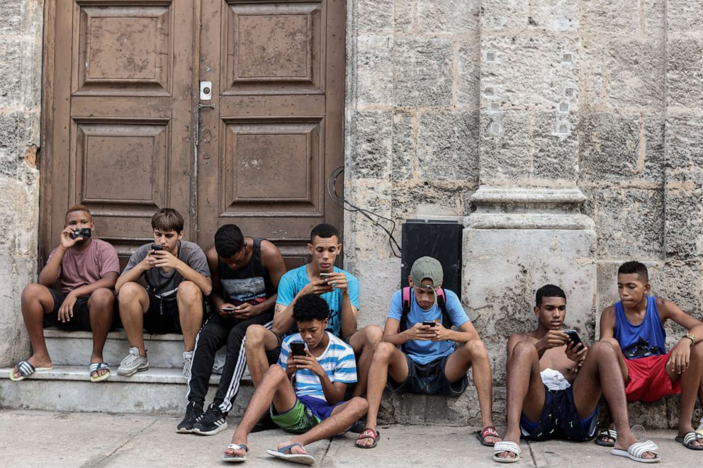 PHOTO: Young people use their smartphones on July, 13, 2019 in Havana, Cuba. The Cuban government began giving 3G mobile internet access to its citizens in 2018.