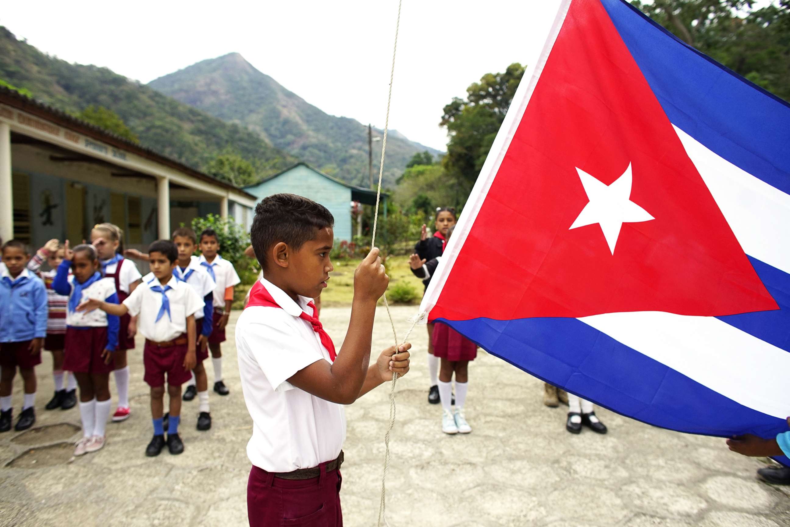PHOTO: A boy raises the Cuban flag during a daily ceremony held at a school in the village of Santo Domingo, in the Sierra Maestra, Cuba, April 2, 2018.