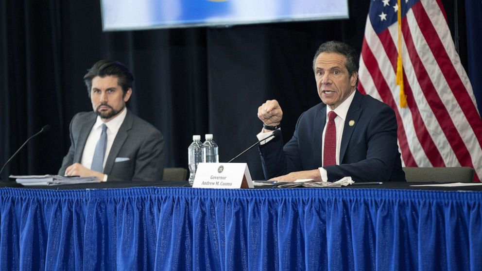 PHOTO: Jim Malatras, President of SUNY Empire State College, left, listens as New York State Governor Andrew Cuomo, right, speaks during his daily coronavirus press briefing at SUNY Upstate Medical University, April 28, 2020 in Syracuse, New York.