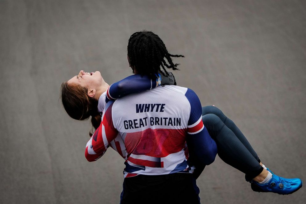 PHOTO: Bethany Shriever of Britain, who won gold in the women's, is carried by Kye Whyte of Britain, who won silver in the men's, as she reacts to winning the women's BMX Racing finals at the 2020 Summer Olympics, Friday, July 30, 2021, in Tokyo, Japan.