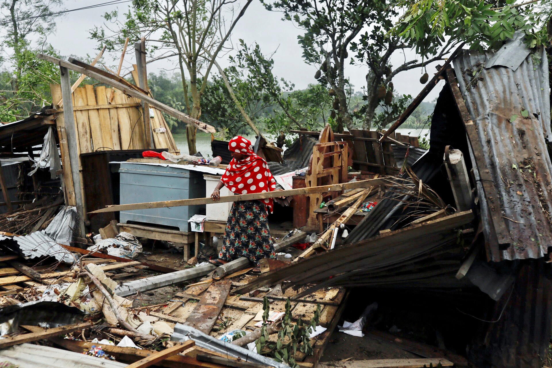 PHOTO: A woman clears her house that was demolished by the cyclone Amphan in Satkhira, Bangladesh May 21, 2020.