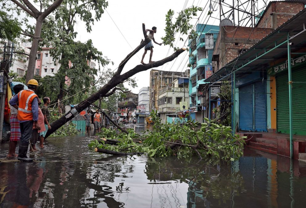 PHOTO: A man cuts branches of an uprooted tree after Cyclone Amphan made its landfall, in Kolkata, India, May 21, 2020.