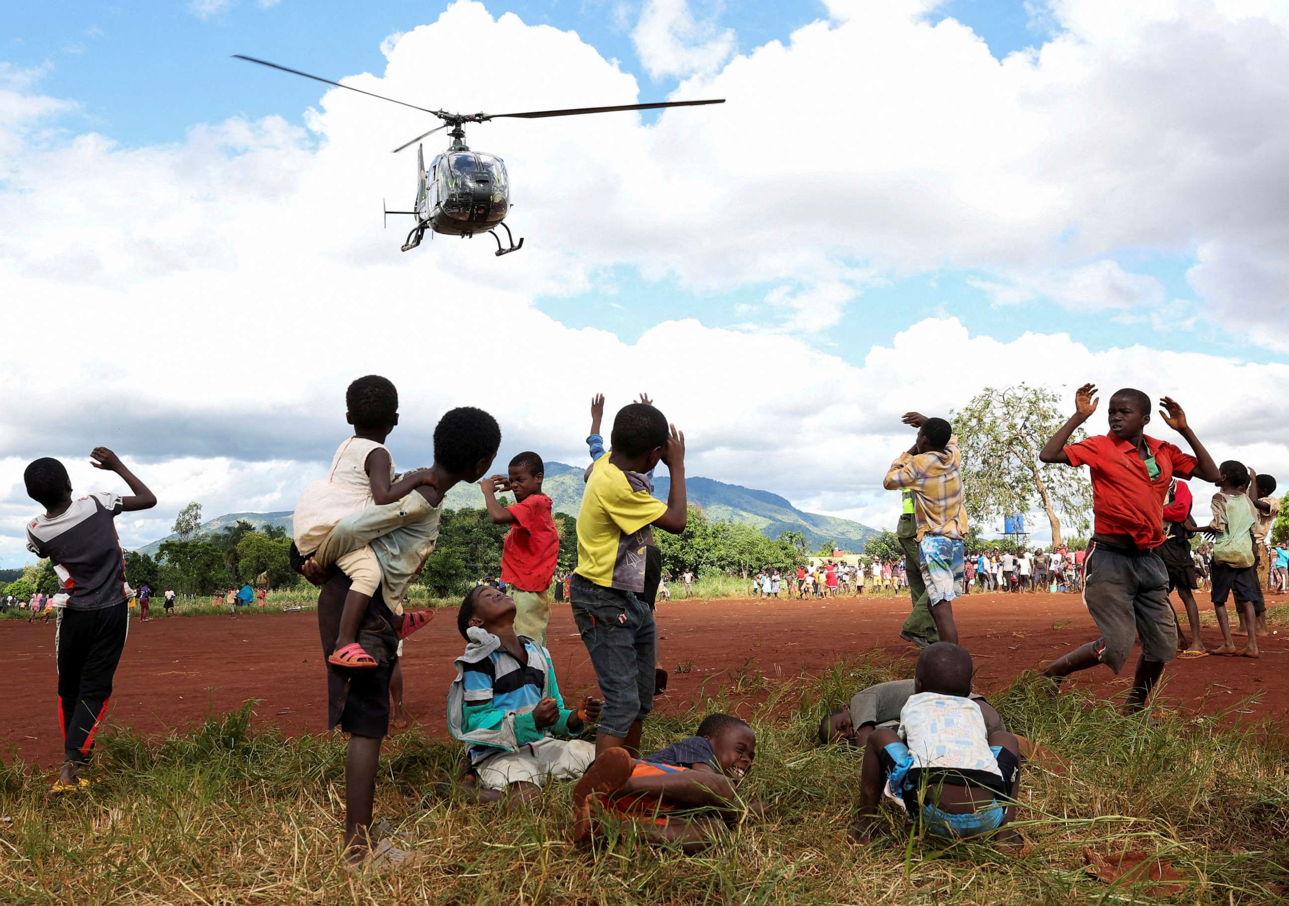 PHOTO: Children in Mulanje look on as a military helicopter carry doctors and medical supplies to Muloza on the border with Mozambique which are cut off after the tropical Cyclone Freddy outside Blantyre, Malawi, March 18, 2023.