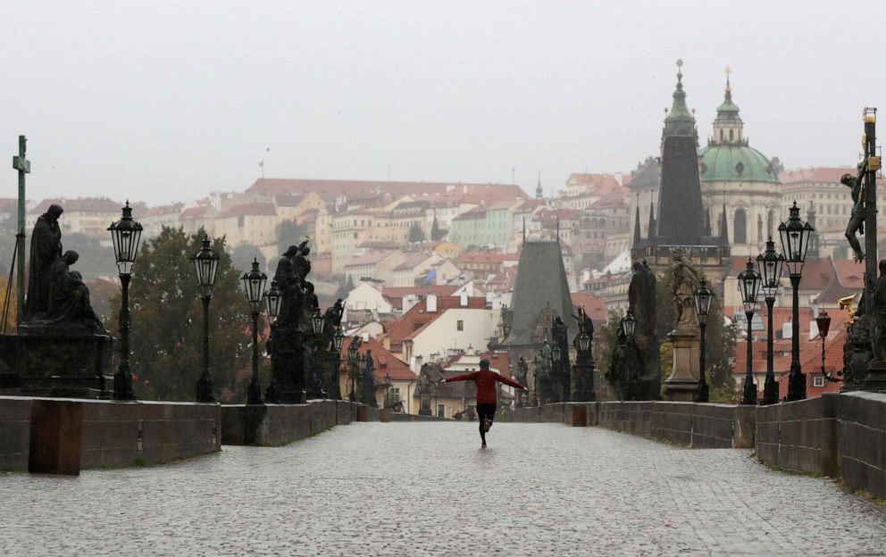 PHOTO: A man runs across an empty medieval Charles Bridge in Prague, Wednesday, Oct. 14, 2020. The Czech Republic has imposed a new series of restrictive measures in response to a record surge in coronavirus infections.