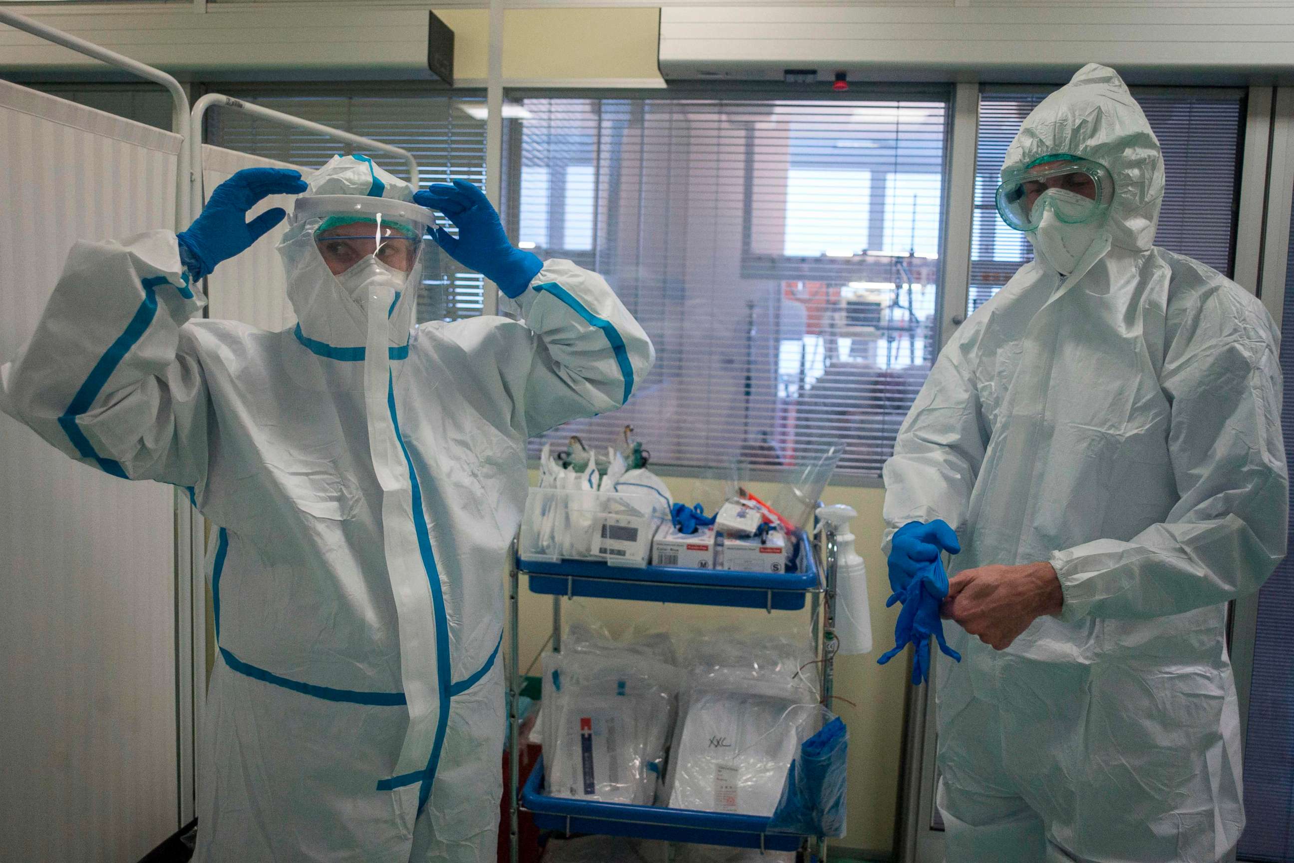 PHOTO: Health care workers wear their personal protective equipment in front of the room for COVID-19 patients in an intensive care unit at Thomayer Hospital on Oct. 14, 2020, in Prague.