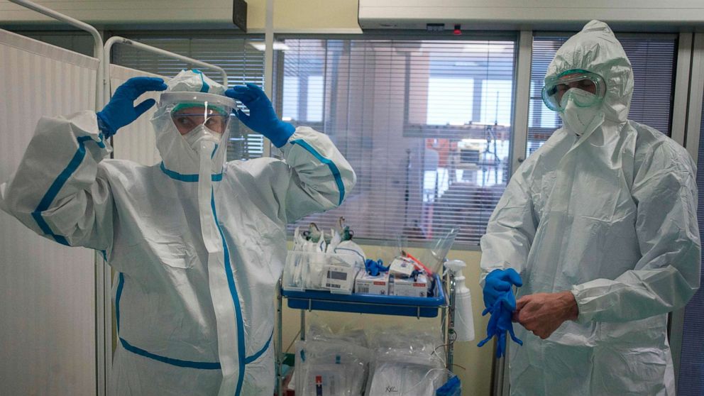 PHOTO: Health care workers wear their personal protective equipment in front of the room for COVID-19 patients in an intensive care unit at Thomayer Hospital on Oct. 14, 2020, in Prague.