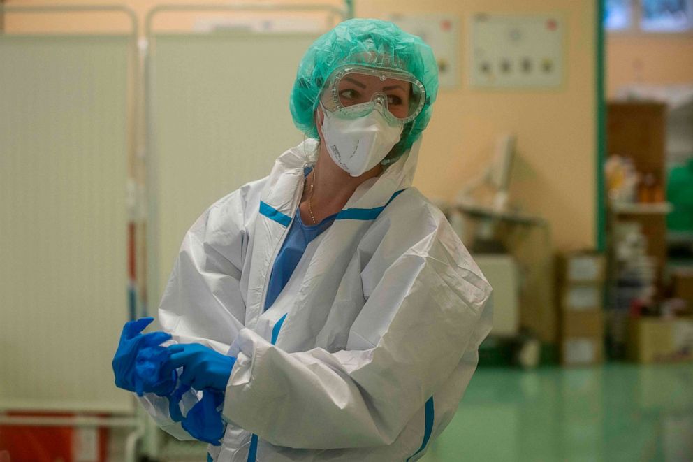 PHOTO: A health care worker puts on personal protective equipment in front of the room for COVID-19 patients in an intensive care unit at Thomayer Hospital on Oct. 14, 2020, in Prague.