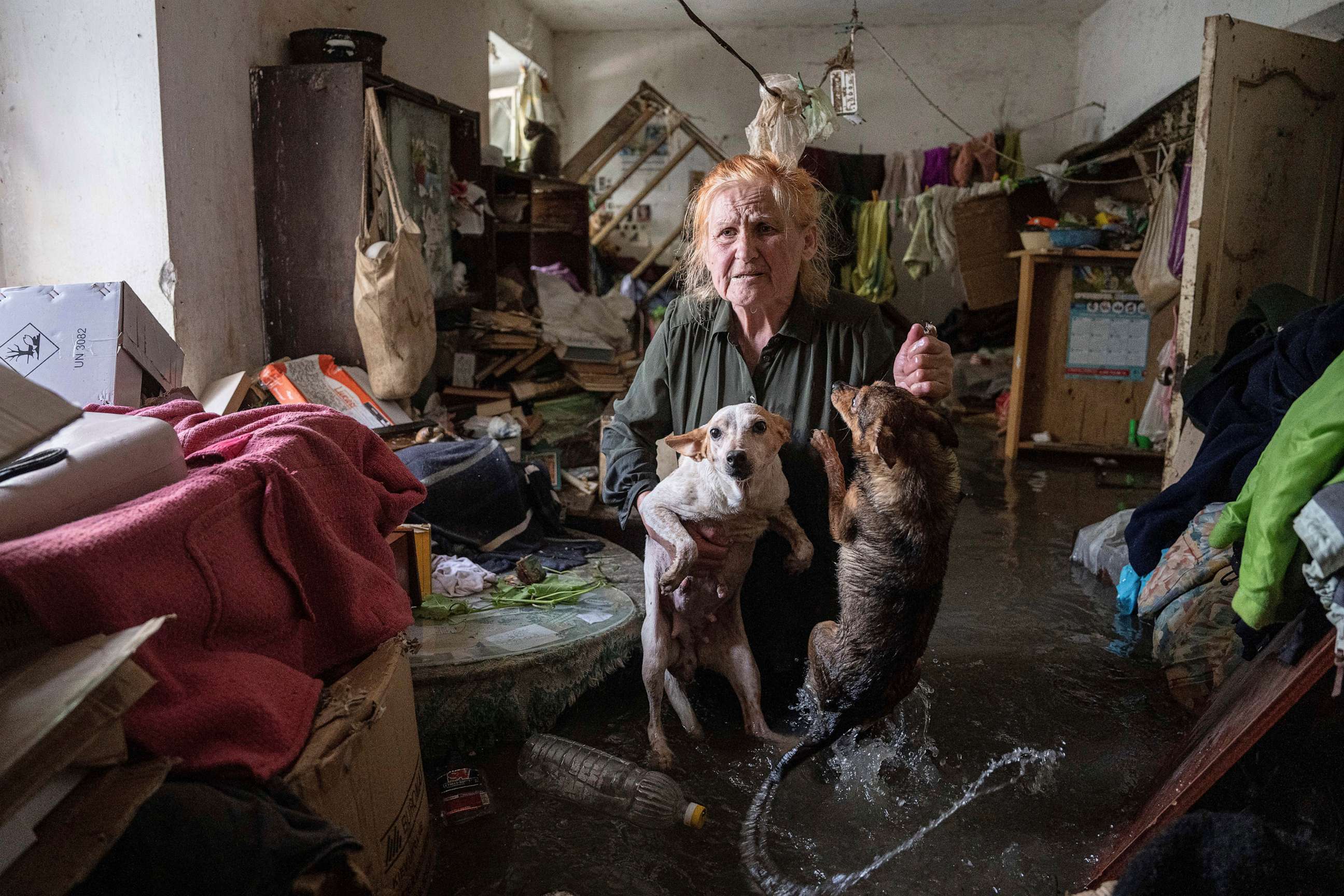 PHOTO: A resident holds her pets, Tsatsa and Chunya, as she stands inside her house that was flooded after the Kakhovka dam blew up overnight, in Kherson, Ukraine, June 6, 2023.