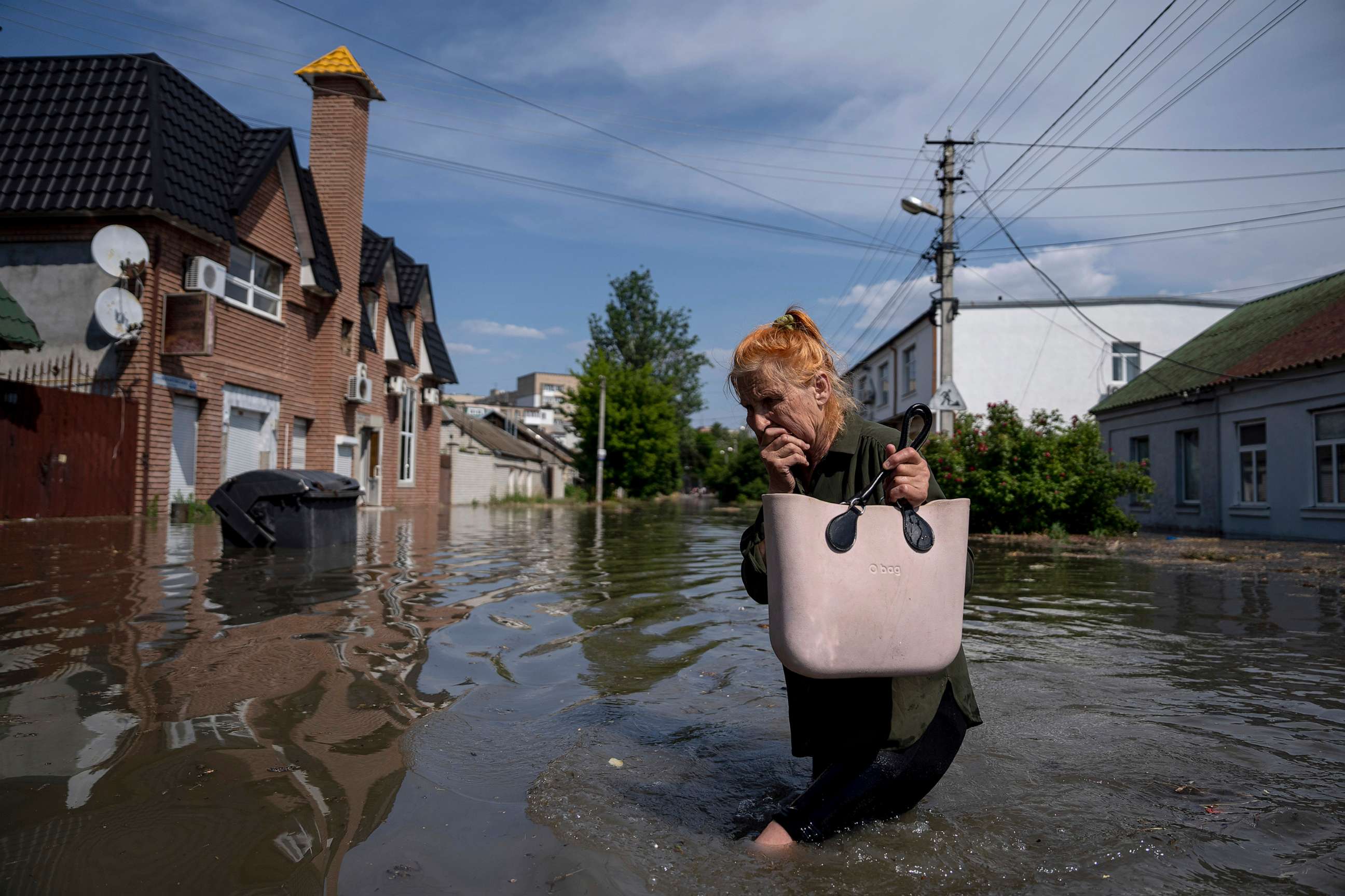 PHOTO: A local resident makes her way through a flooded road after the walls of the Kakhovka dam collapsed overnight, in Kherson, Ukraine, June 6, 2023.