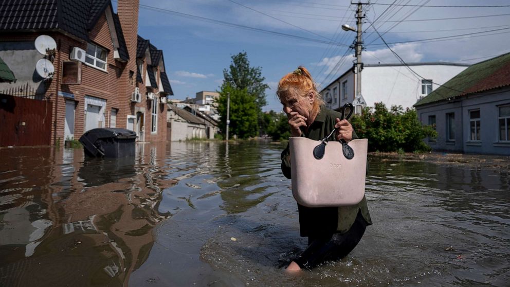 PHOTO: A local resident makes her way through a flooded road after the walls of the Kakhovka dam collapsed overnight, in Kherson, Ukraine, June 6, 2023.