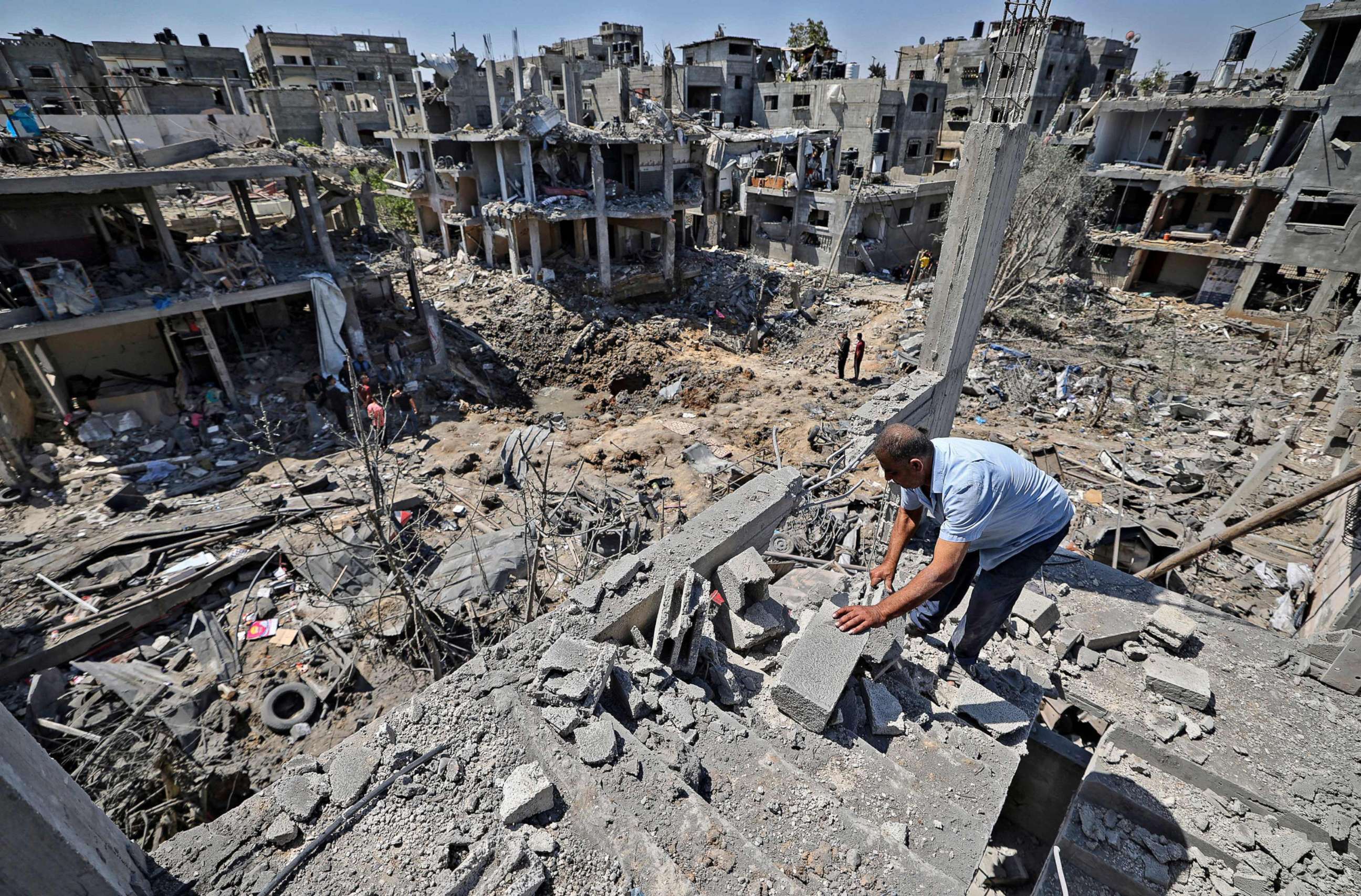 PHOTO: Palestinians assess the damage caused by Israeli air strikes, in Beit Hanun in the northern Gaza Strip, May 14, 2021.