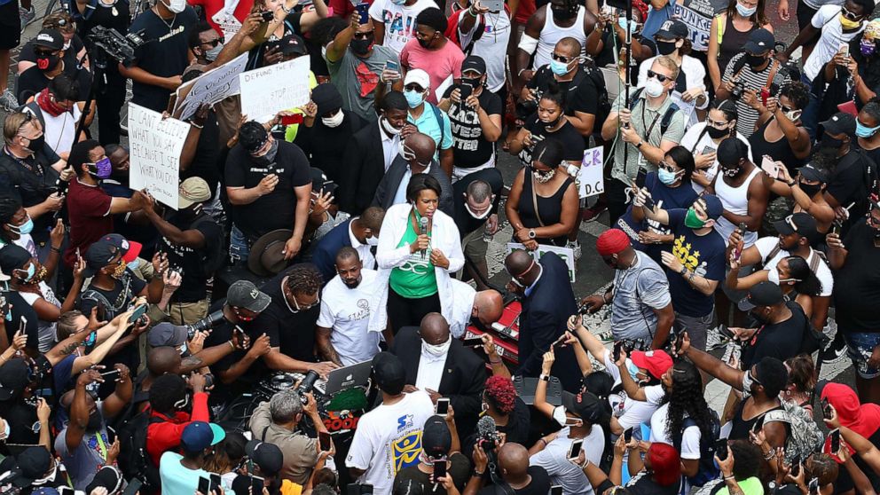 PHOTO: DC Mayor Muriel Bowser, center, speaks to demonstrators gathered on the newly named Black Lives Plaza during a peaceful protest against police brutality and racism, on June 6, 2020 in Washington.