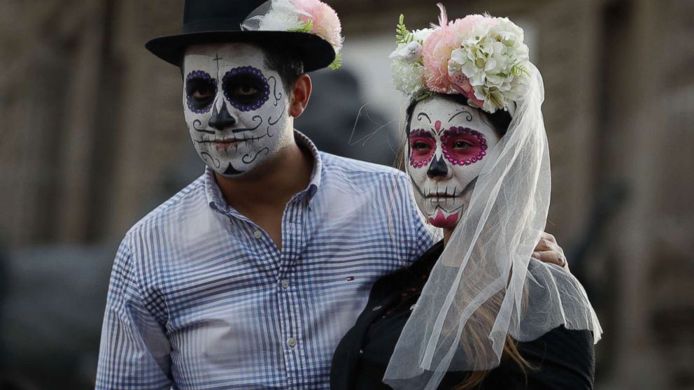 PHOTO: People dressed as a skeleton couple await the start of the Grand Procession of the "Catrinas," part of upcoming Day of the Dead celebrations in Mexico City, Oct. 22, 2017.