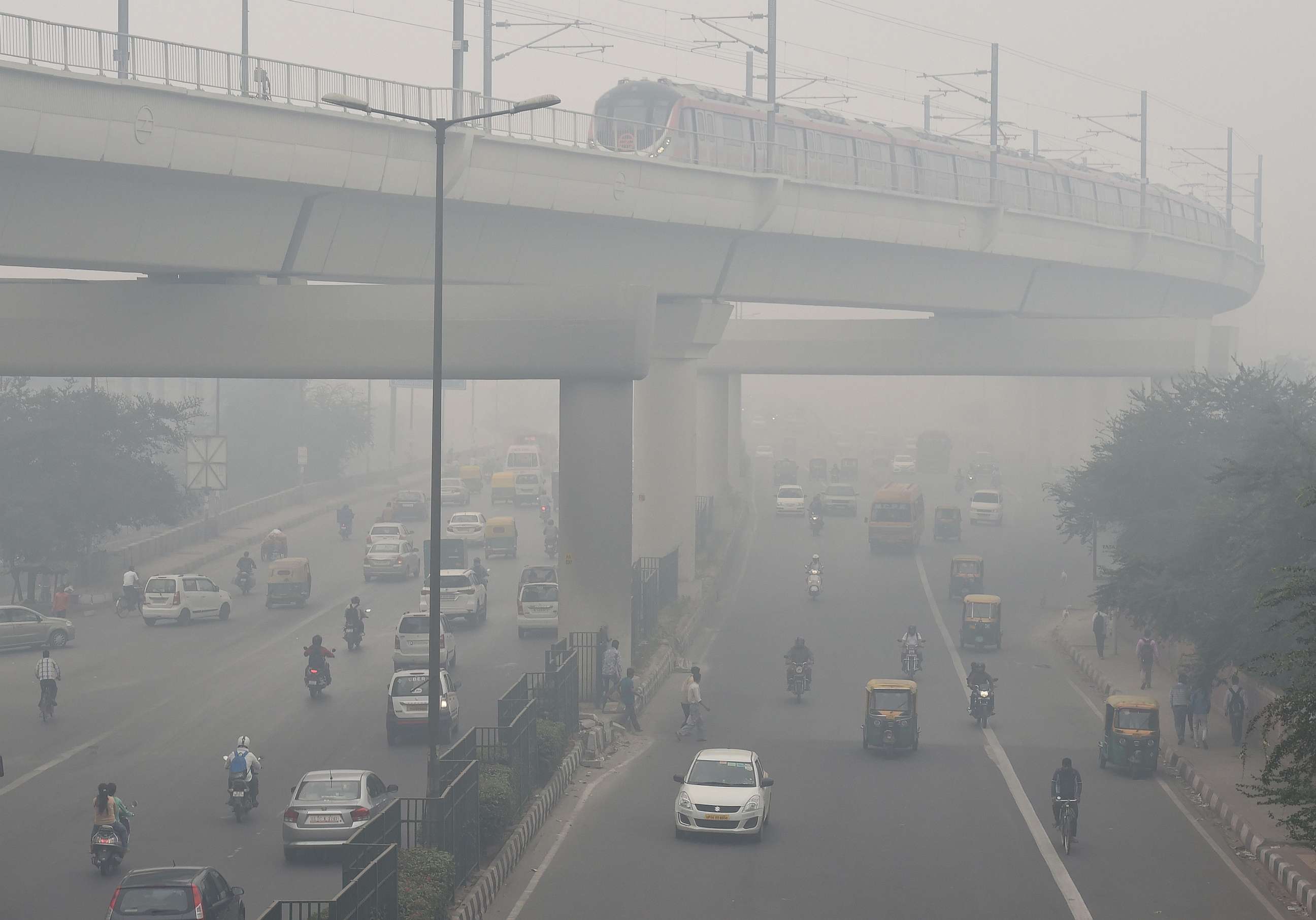 PHOTO: A Delhi Metro train and vehicles drive past heavy smog in New Delhi, Nov. 5, 2018.