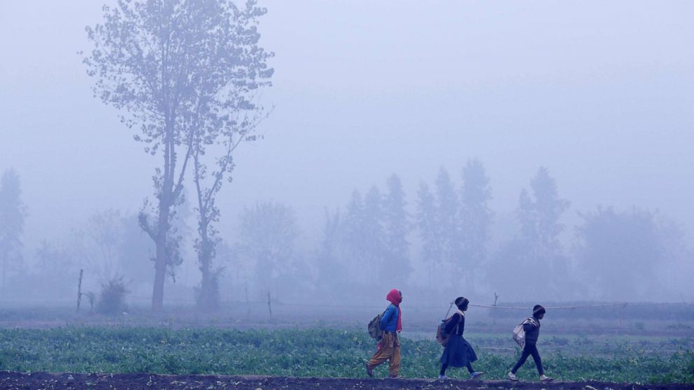 Children walk to school amidst heavy fog on a winter morning in New Delhi, India on Jan. 4, 2018.
