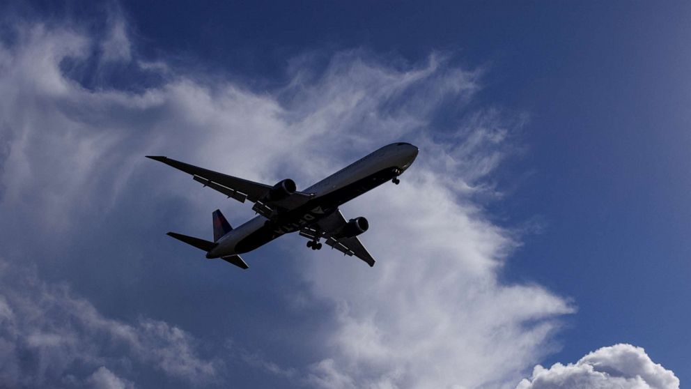 In this file photo, a Delta Airlines flight descends past stormy clouds as it approaches to land in San Diego, California, U.S., December 12, 2022.