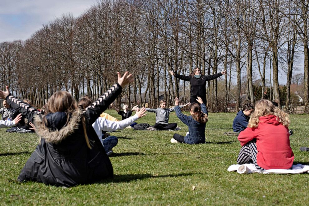 PHOTO: Rebekka Hjorth holds a music lesson outdoors with her class at the Korshoejskolen school, after it reopened following the lockdown to control the spread of COVID-19, in Randers, Denmark, April 15, 2020.