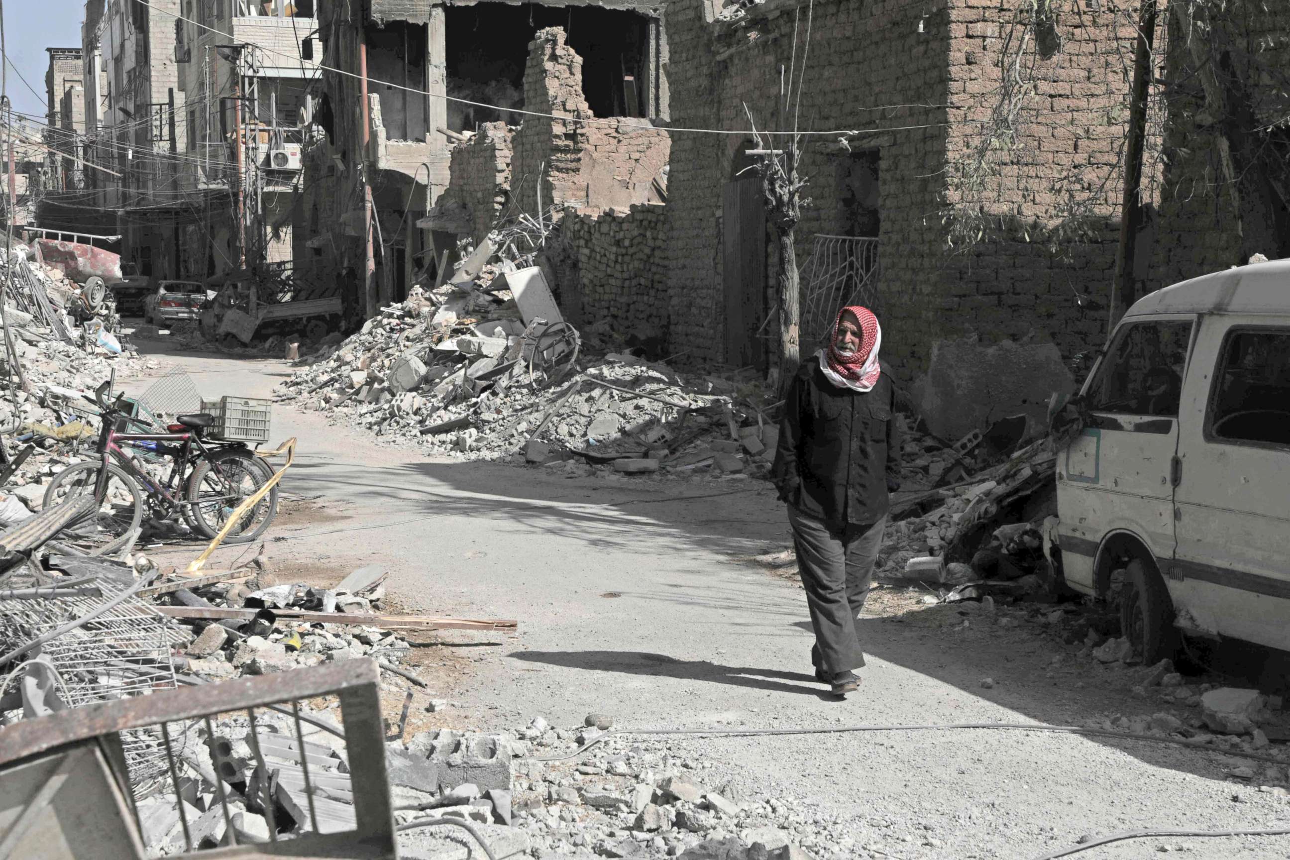 PHOTO: A Syrian man walks down a street past destroyed buildings, March 25, 2018, in Douma, in Eastern Ghouta on the outskirts of the capital Damascus.