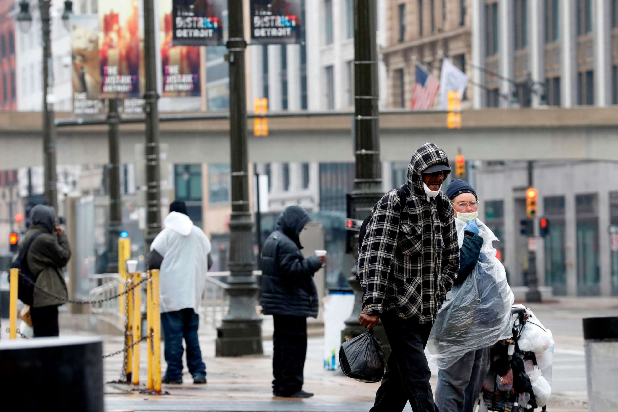 PHOTO: People wait for a bus as they wait on Woodward Avenue in Detroit, April 7, 2020.