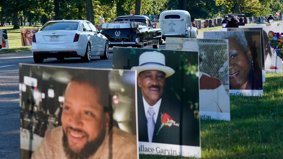 PHOTO: A procession of vehicles drive past photos of Detroit victims of COVID-19, Aug. 31, 2020, on Belle Isle in Detroit.