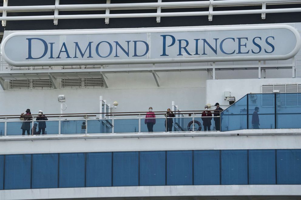 PHOTO: Passengers on board the Diamond Princess cruise ship are seen as it arrives at Daikoku Pier where it is being resupplied and newly diagnosed coronavirus cases taken for treatment as it remains in quarantine, in Yokohama, Japan, Feb. 12, 2020.