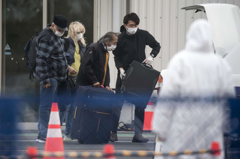 PHOTO: Passengers are assisted while loading bags into a taxi after disembarking from the quarantined Diamond Princess cruise ship, docked at the Daikoku Pier in Yokohama, Japan, on Feb. 20, 2020. 