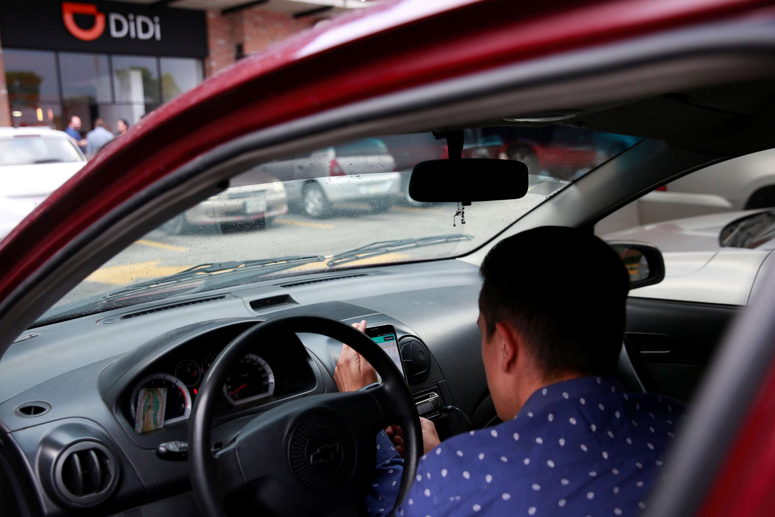 PHOTO: A new DIDI driver set up his mobile phone inside a car outside the new drivers center of the Chinese ride-hailing firm in Toluca, Mexico, April 23, 2018.