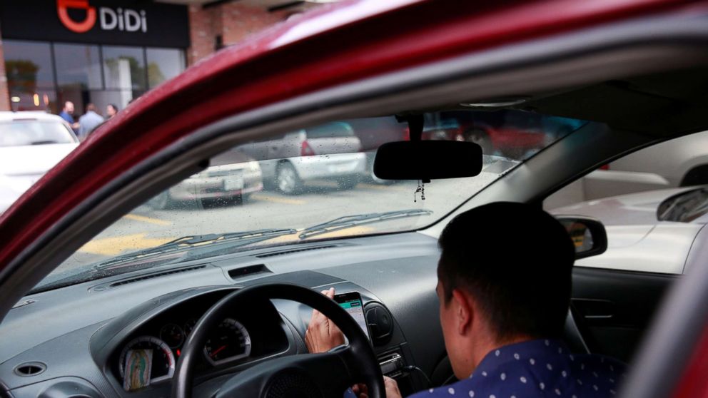 A new DIDI driver set up his mobile phone inside a car outside the new drivers center of the Chinese ride-hailing firm in Toluca, Mexico, April 23, 2018.