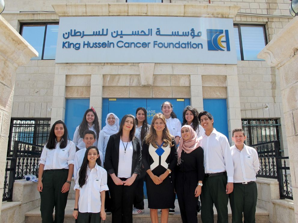 PHOTO: Dina Mired stands outside the King Hussein Cancer Center with students visiting the facilities.
