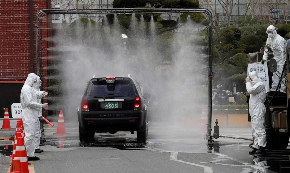 PHOTO: South Korean soldiers in protective gear use a machine to spray disinfectant on visiting cars at Kyungpook National University Hospital in Daegu, South Korea, March 3, 2020.