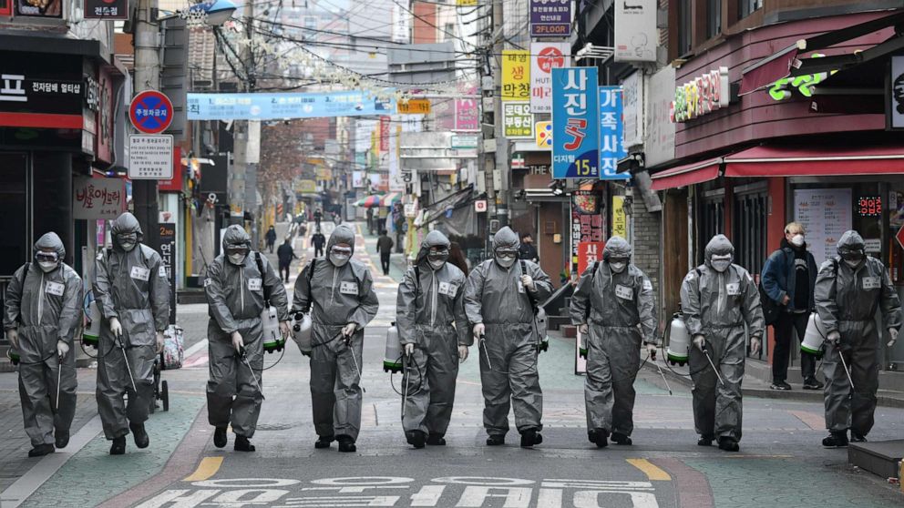 PHOTO: South Korean soldiers wearing protective gear spray disinfectant to help prevent the spread of the novel coronavirus, at a shopping district in Seoul on March 4, 2020.