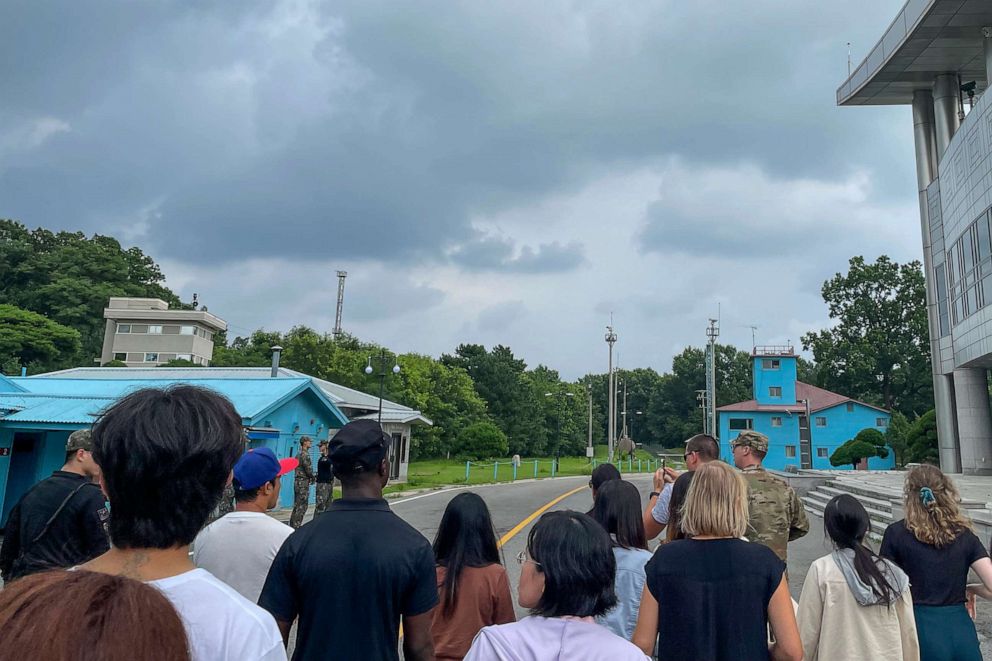 PHOTO: A group of tourists stand near a border station at Panmunjom in the Demilitarized Zone in Paju, South Korea, July 18, 2023.