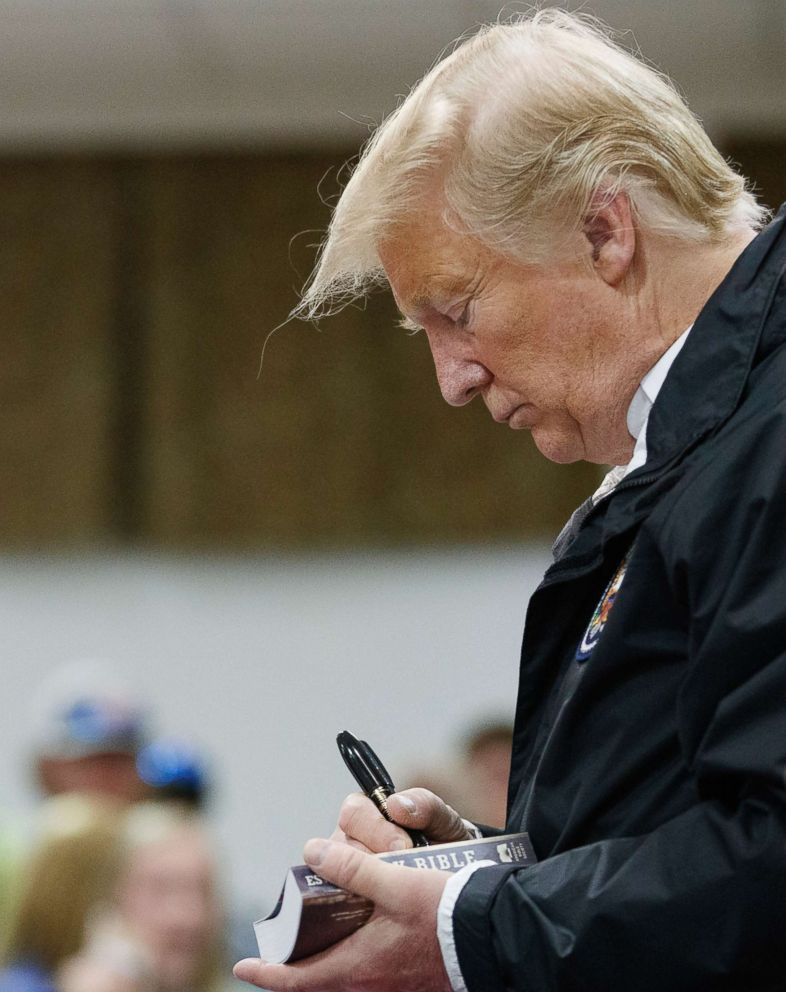 PHOTO: President Donald Trump signs a Bible as he greets people at Providence Baptist Church in Smiths Station, Ala., as he tours areas where tornadoes killed 23 people in Lee County, Ala., Friday, March 8, 2019.