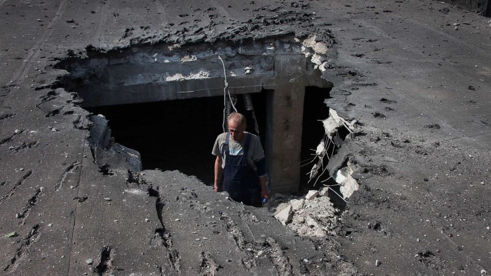 PHOTO: A man examines the roof of a hospital damaged during shelling in Donetsk, in territory under the government of the Donetsk People's Republic, eastern Ukraine, on June 14, 2022.