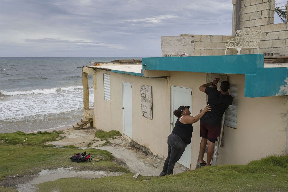PHOTO: Ya Mary Morales and Henry Sustache put plywood over the windows of their home as they prepare for the arrival of Tropical Storm Dorian on Aug. 28, 2019 in Yabucoa, Puerto Rico.