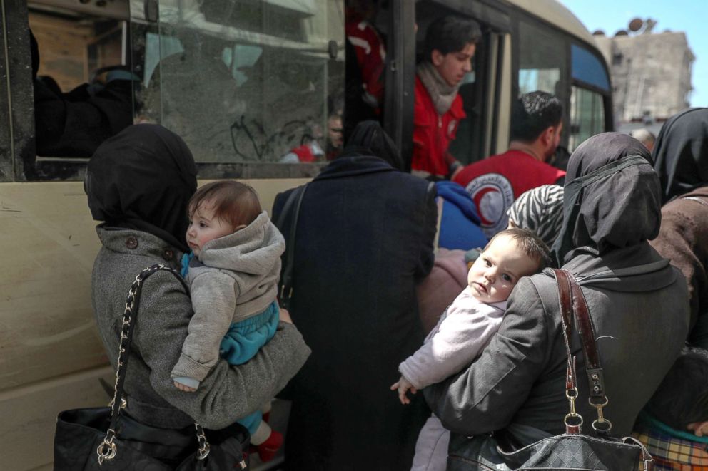 PHOTO: People wait in front of a bus during the second day of evacuation in rebels-held Douma, Syria, March 14, 2018.