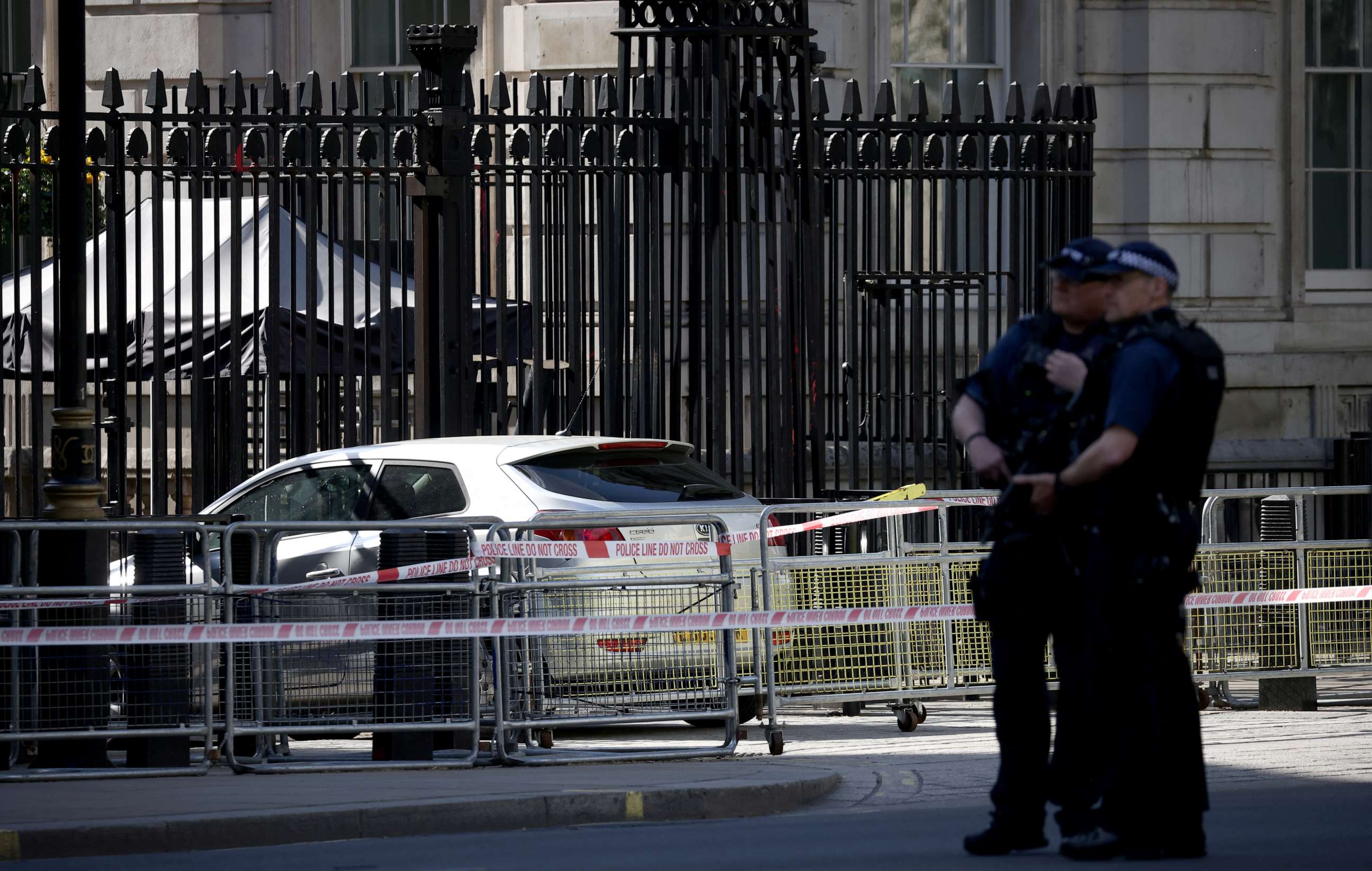 PHOTO: Police officers stand guard neat the site where a car crashed into the front gates of Downing Street in London, Britain, May 25, 2023.
