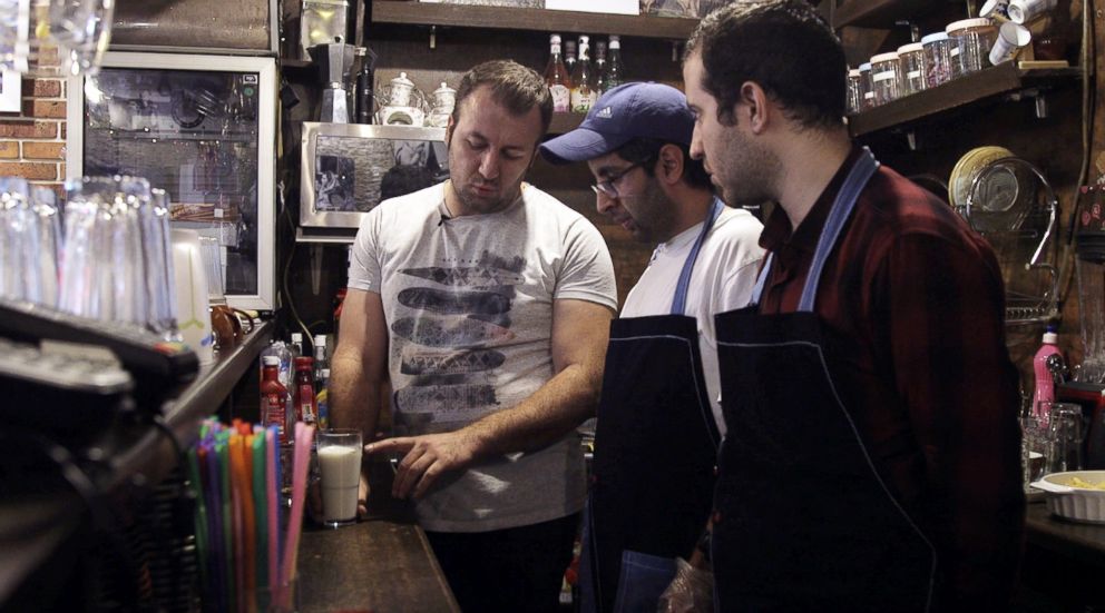 PHOTO: Staff members Shahriyar Sobhdel, center, and Mehdi Khakian, right, listen to a trainer at the Downtism Cafe, in Tehran, Iran, on Dec. 11, 2018.