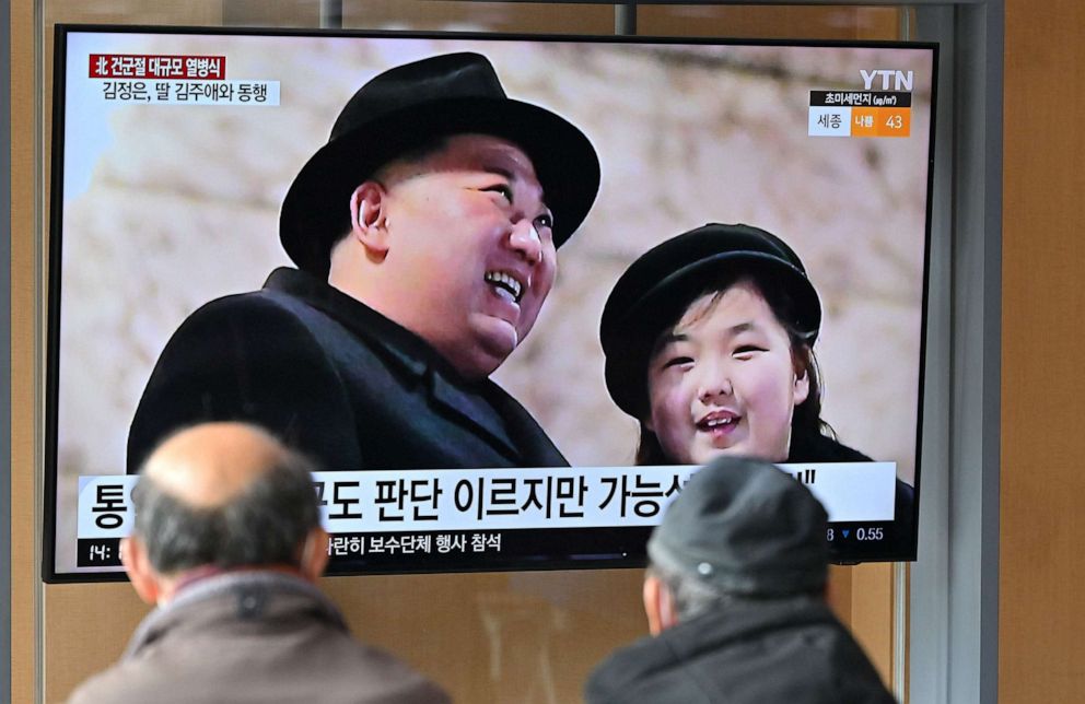 PHOTO: People watch a television screen showing a news broadcast with an image of North Korean leader Kim Jong Un and his daughter attending a military parade held in Pyongyang, at a railway station in Seoul on Feb. 9, 2023.